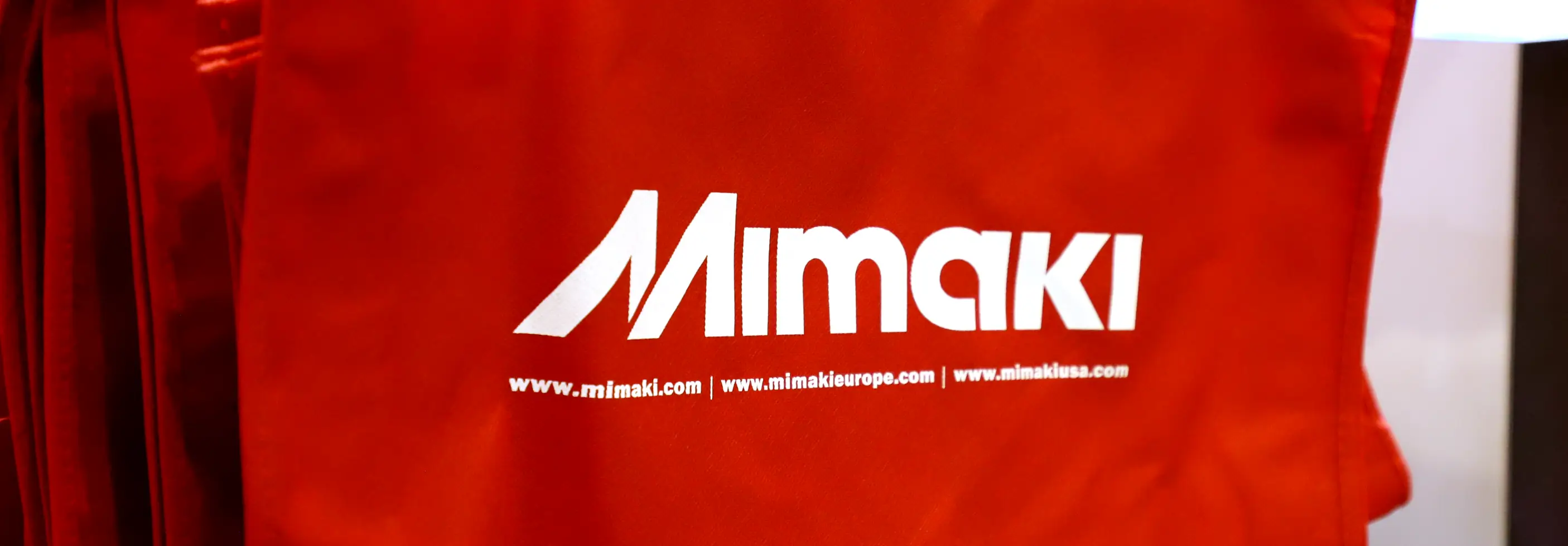 Red tote bag with Mimaki logo printed on it