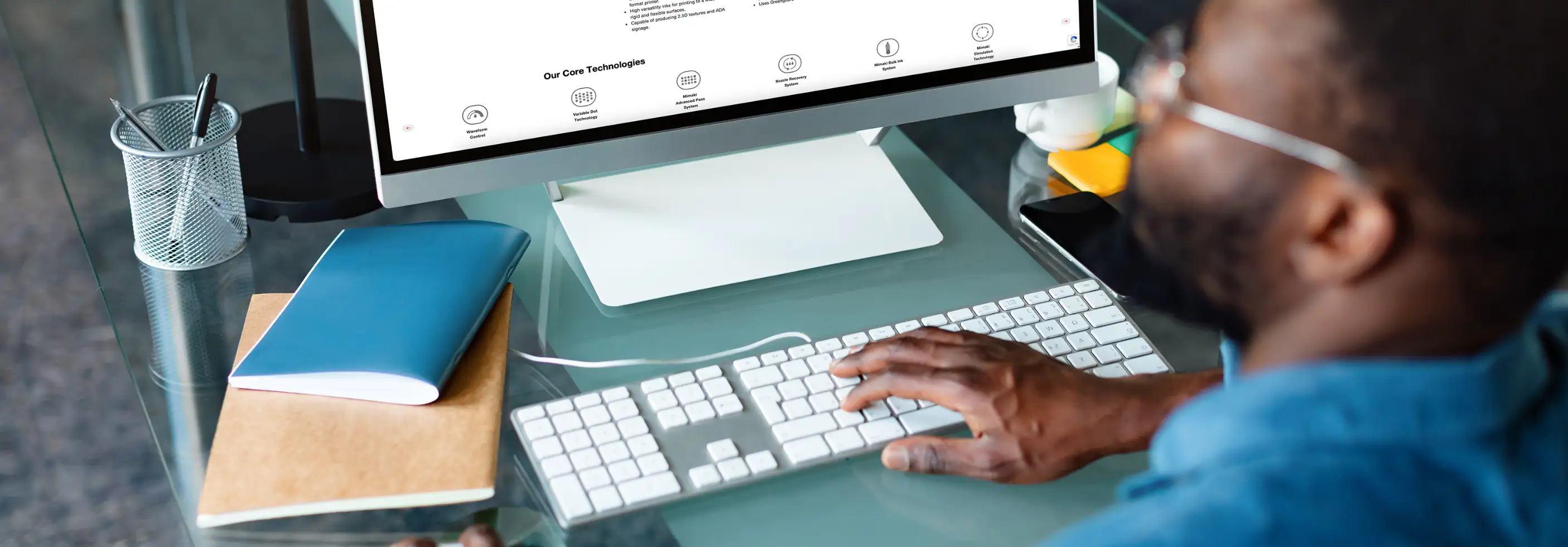 A man looking at the Mimaki Website on his computer